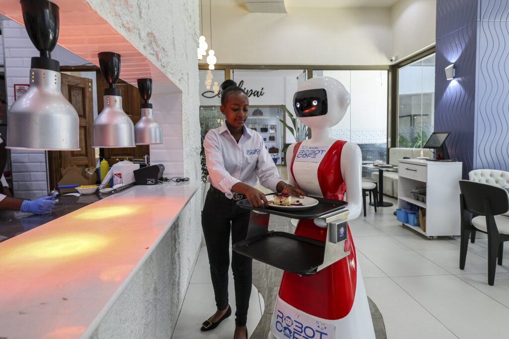 A waiter placing food order on a robotic waiter for delivery PHOTO| Daily sabah